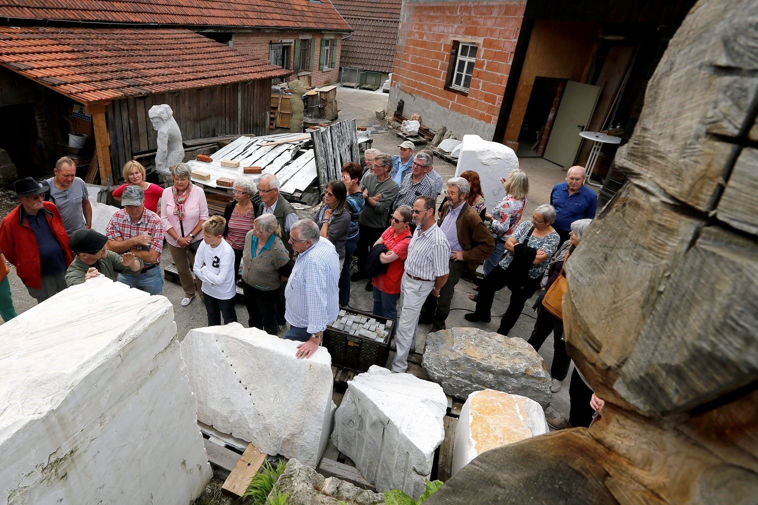 Der Künstler Michael Schützenberger erklärt auf seinem Bildhauerhof, wie er Steine bearbeitet. Foto: privat