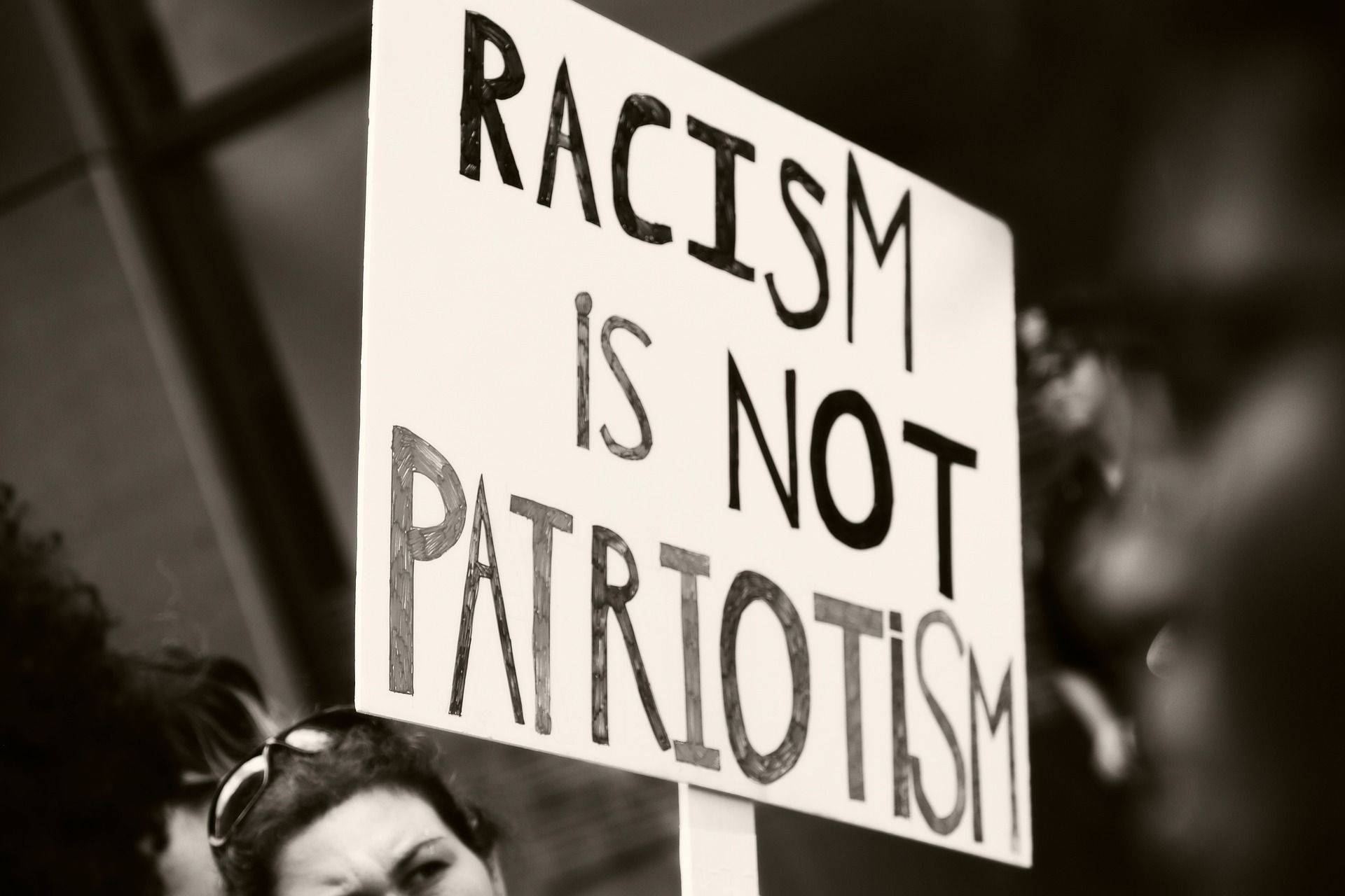 Schild mit der Auffschrift: "Racism is not patriotism"